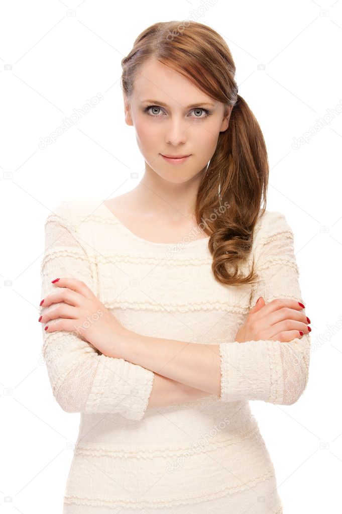 Beautiful young serious woman crossed her arms on a white background