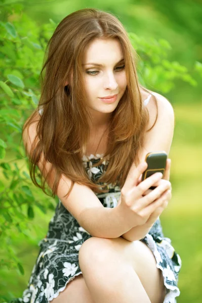 Gyönyörű fiatal nő mobiltelefonnal — Stock Fotó