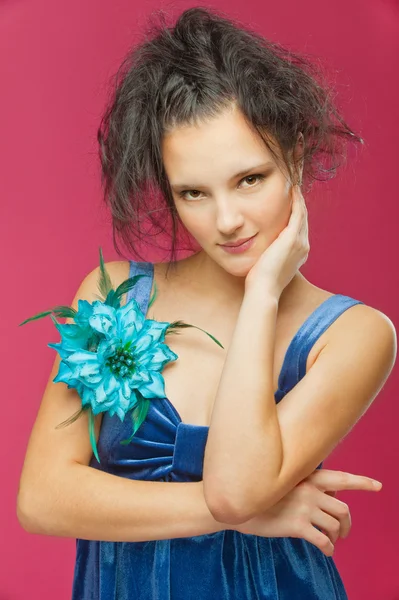 美丽的年轻女子在一件红色的背景上的蓝色连衣裙 — 图库照片
