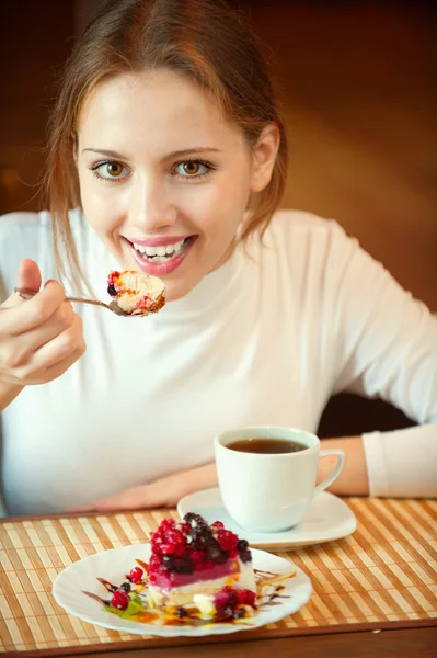 Chica sonriente se sienta a la mesa en la cafetería —  Fotos de Stock
