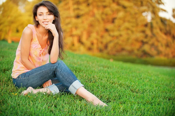 妇女坐在绿草地上 — 图库照片