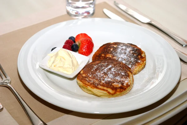 stock image Plate of fresh cheese pancakes, butter and strawberries over table