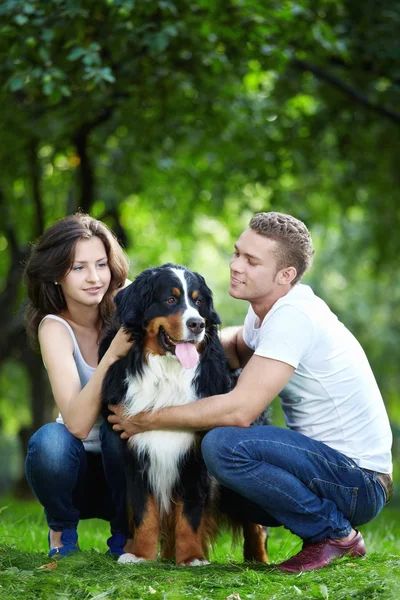 The happy couple with a dog — Stock Photo, Image