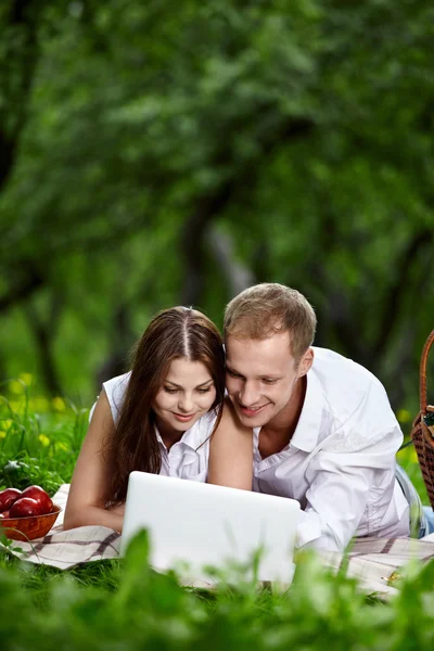 Couple avec l'ordinateur portable dans le parc — Photo