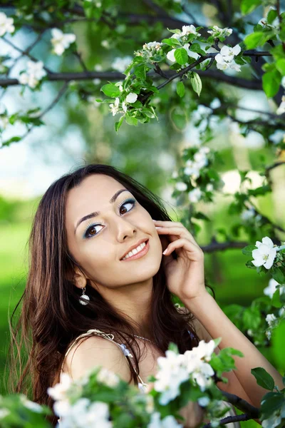 花盛りの木の背景に魅力的な女の子 — ストック写真