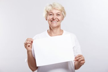 Mature woman smiling with an empty plate on a white background clipart