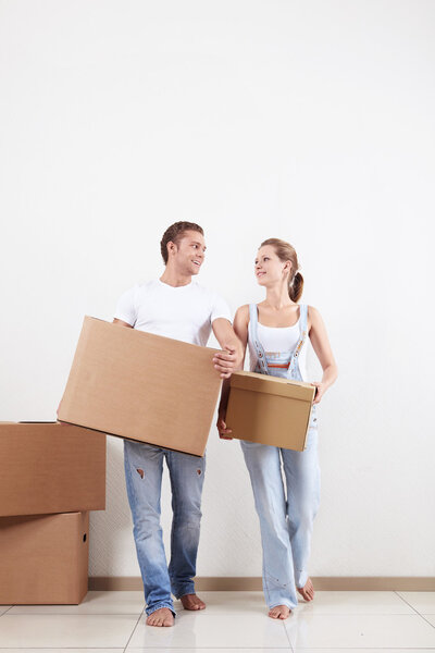 A young couple moves boxes in apartment