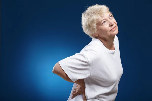Eine Ältere Frau Mit Krankem Rücken Auf Blauem Hintergrund — Stockfoto