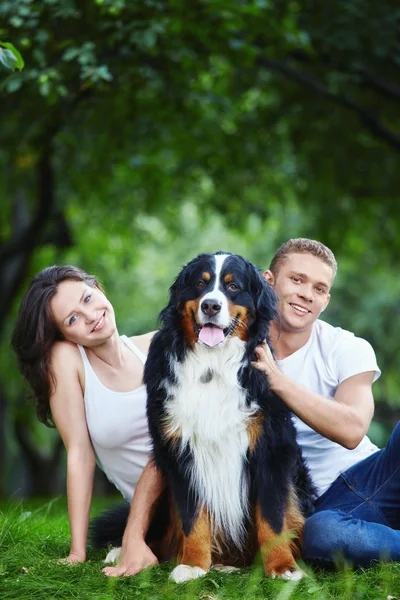 Um casal com um cão no parque — Fotografia de Stock