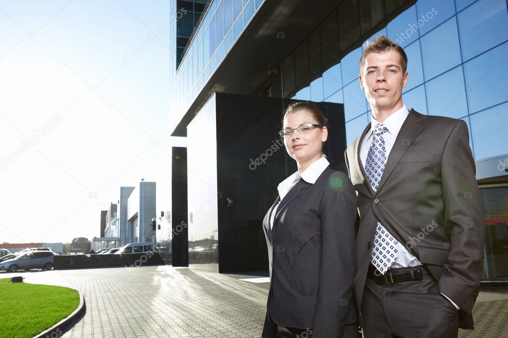 Business in suits with business building