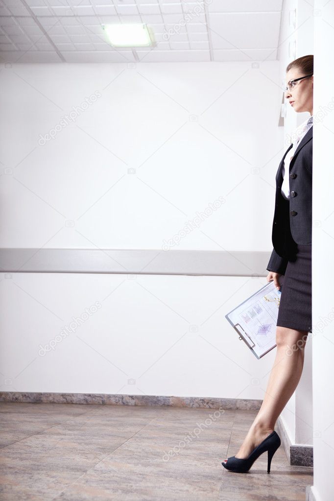 A young girl in a serious suit goes out the door