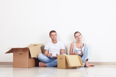 Young couple drinking coffee on the floor clipart