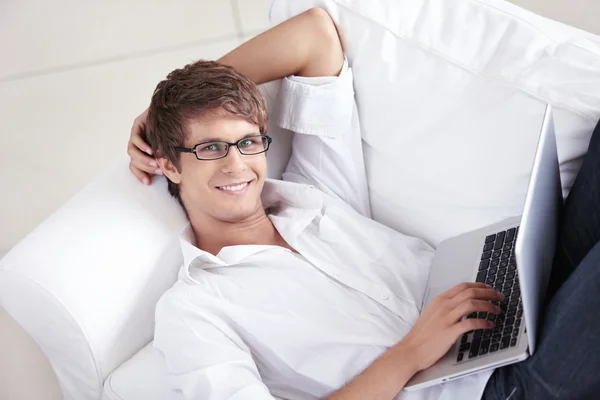 ノート パソコン ソファの上で魅力的な男性 — ストック写真