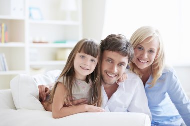 Young parents with young daughter at home clipart