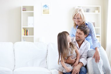 Young parents with young daughter at home clipart