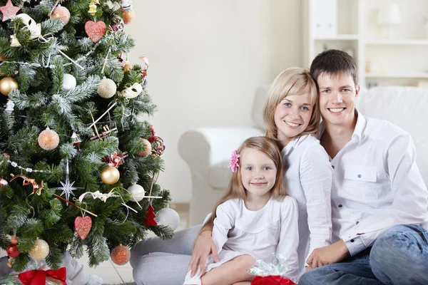 クリスマス ツリーを自宅で若い幸せな家族 — ストック写真