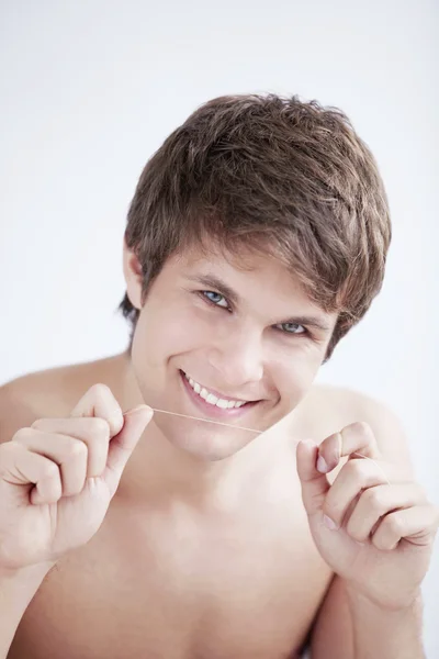 Красивий чоловік з зубною ниткою — стокове фото