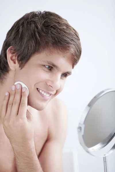 Attractive Man Rubs Lotion Face Mirror — Stock Photo, Image