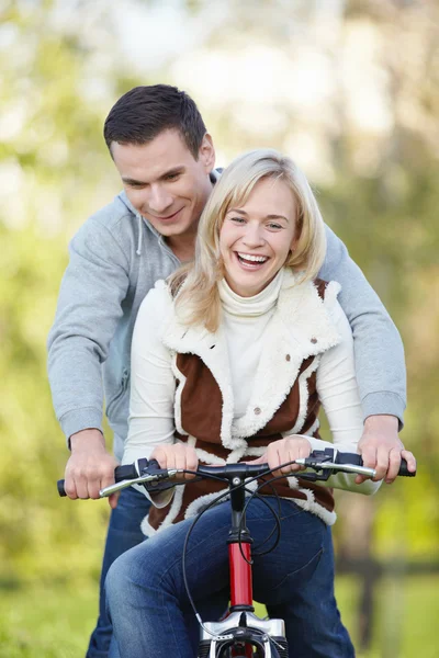 Νεαρό ζευγάρι ελκυστική βόλτες με ένα ποδήλατο — Φωτογραφία Αρχείου