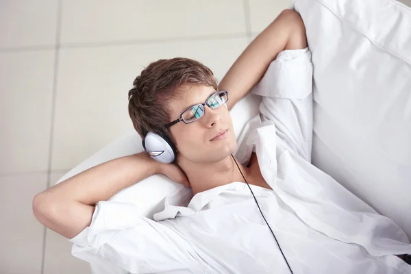 En ung man lyssnar på musik — Stockfoto