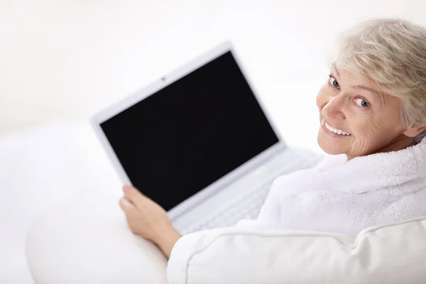 微笑的老女人用一台笔记本电脑 — 图库照片