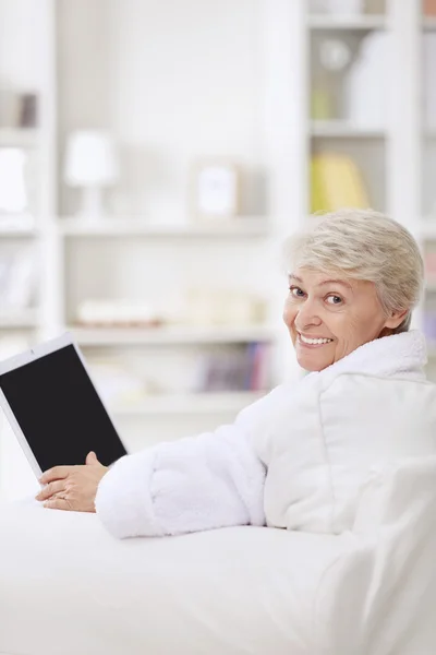 Uma mulher sorridente com um laptop — Fotografia de Stock