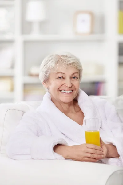 微笑的浴袍和一杯果汁有吸引力的女人 — 图库照片