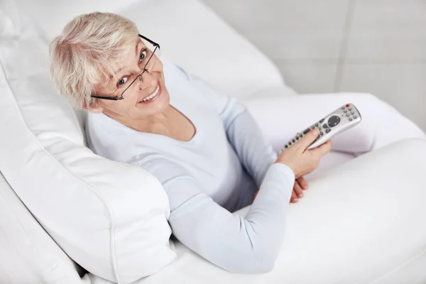 Eine Ältere Frau Auf Der Couch Mit Fernbedienung Fernseher — Stockfoto