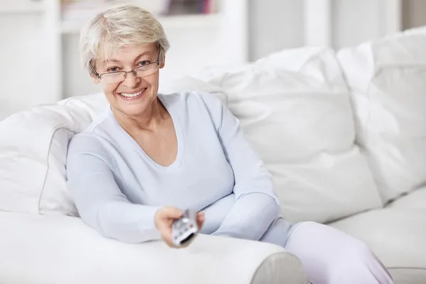 Mature Woman Remote Control Changes Channels — Stock Photo, Image