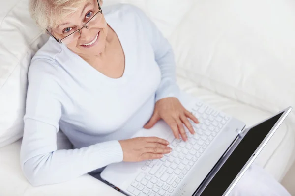 Atrakcyjna Kobieta Średnim Wieku Laptopa Białej Kanapie — Zdjęcie stockowe