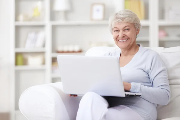 Ένα Χαμογελαστό Μεσήλικας Γυναίκα Ένα Φορητό Υπολογιστή Στο Σπίτι — Φωτογραφία Αρχείου