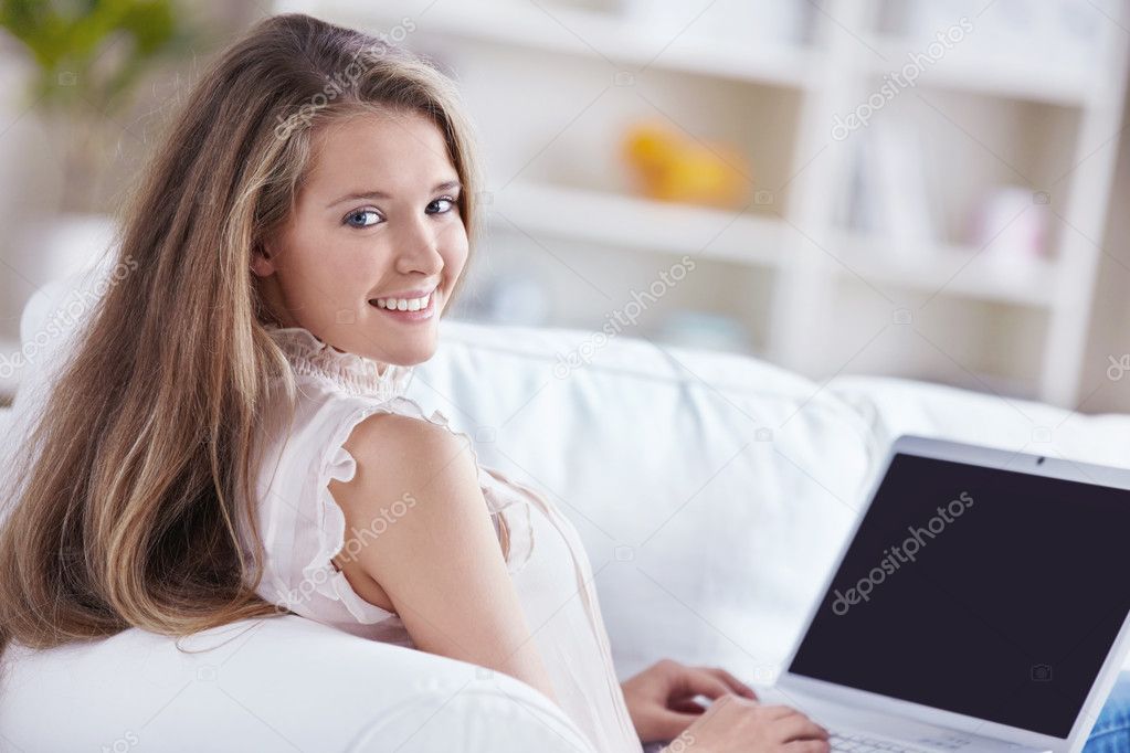A beautiful young girl with a laptop at home