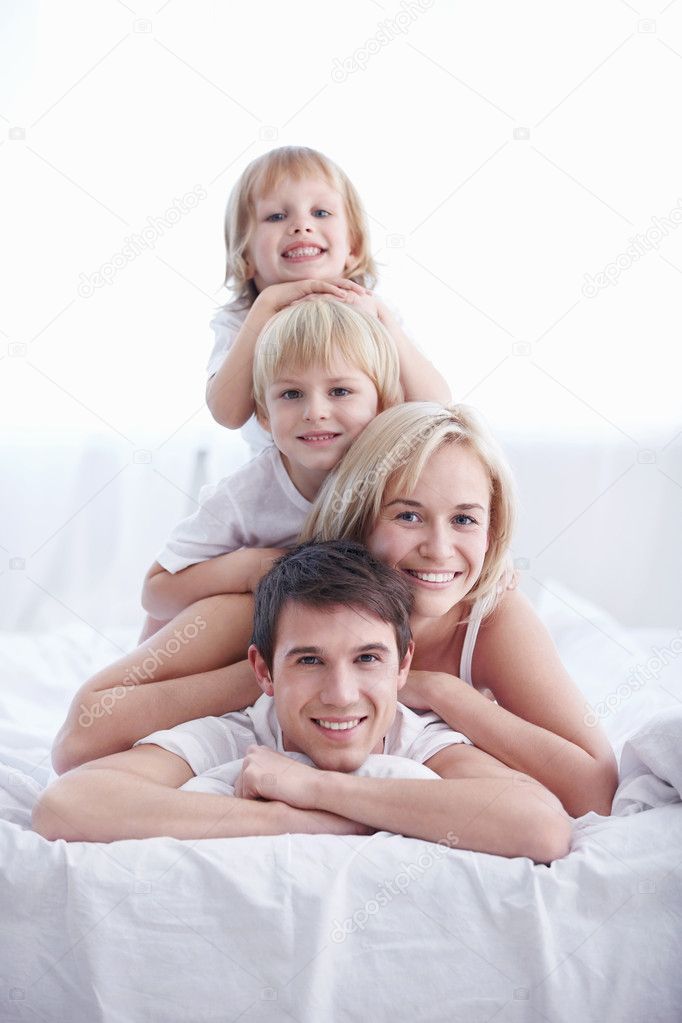 A happy family with two children in the bedroom