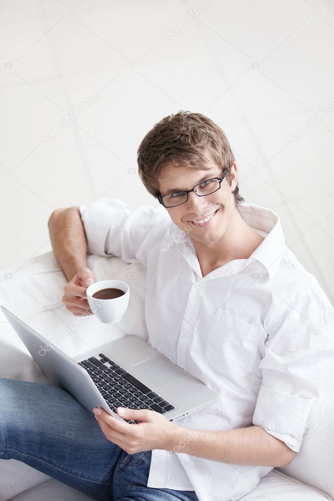 Laughing young man with laptop