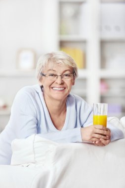 An attractive middle-aged woman with a glass of juice clipart