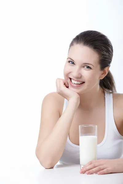 Menina sorridente com um copo de leite — Fotografia de Stock