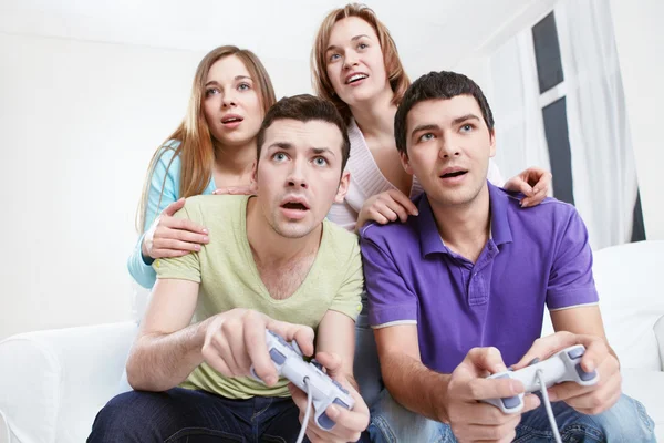 Молодые друзья играют в компьютерные игры — стоковое фото