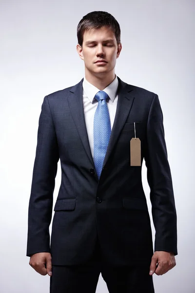 Серьезный бизнесмен в костюме с биркой — стоковое фото