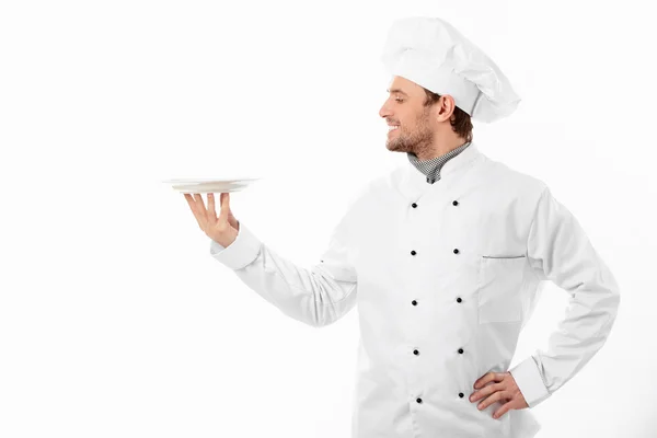 Young cook holding an empty plate — Stock Photo, Image