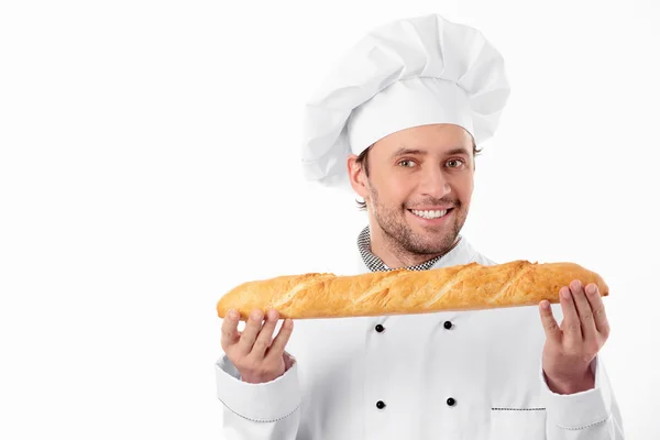 Un jeune boulanger tient un pain — Photo