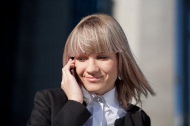 Genç iş kadını telefonda konuşuyor.