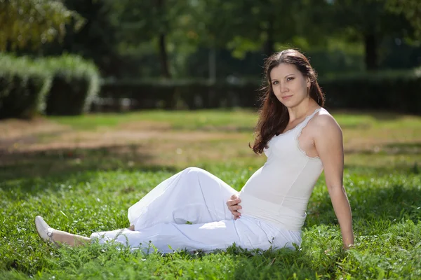 Pregnant woman sitting outdoor — Stock Photo, Image