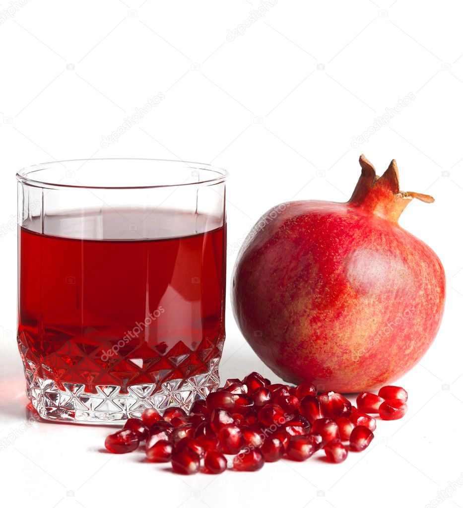 Glass filled by juice of a pomegranate and the seeds of a pomegr