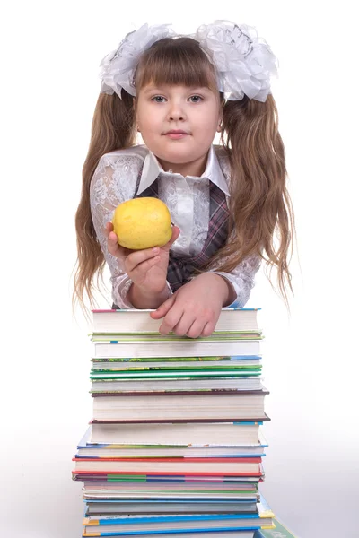 Schoolmeisje leunend op een stapel boeken — Stockfoto
