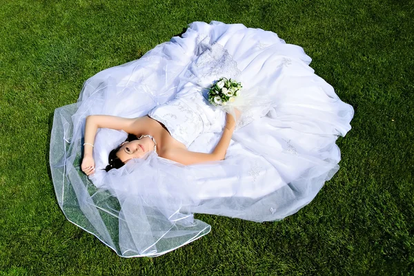 Braut liegt auf einem Brautkleid — Stockfoto