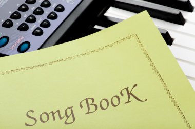 Piano keyboard with song book clipart