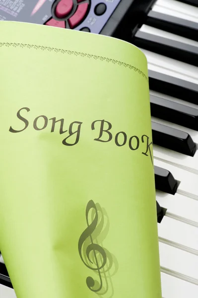 Teclado piano com livro de música de perto — Fotografia de Stock