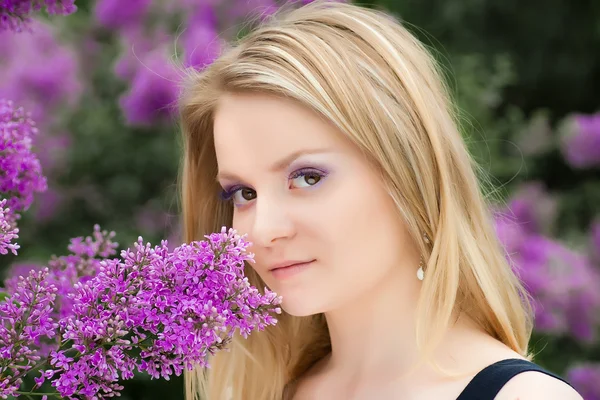 Portrait of blonde girl near the lilacs — Stock Photo, Image