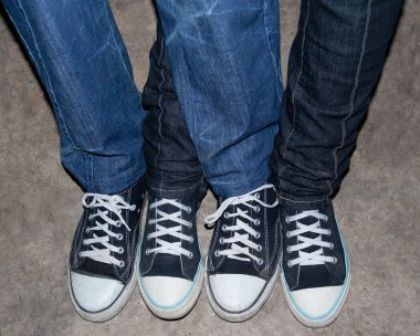 Girl and boy in jeans and black sneakers. clipart
