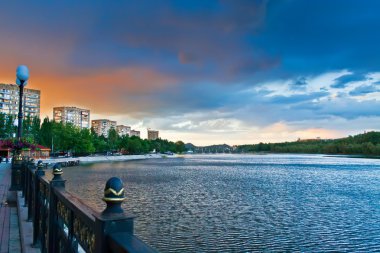 Houses trees and clouds reflected in a river. Donetsk, Ukraine clipart